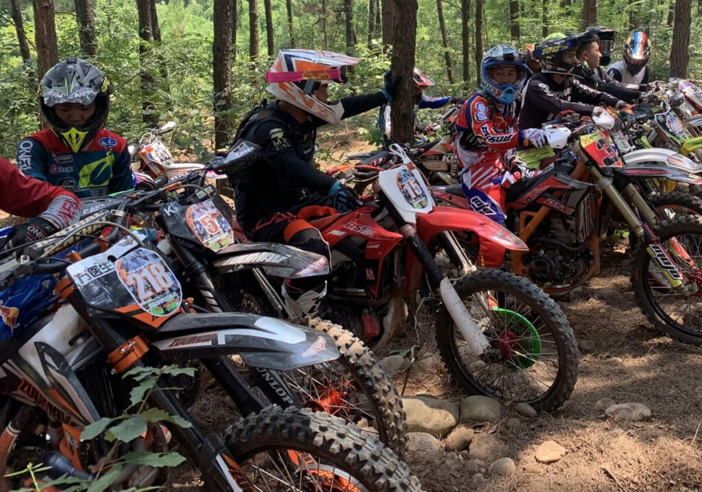 A group of riders driving light dirt bike in the woods