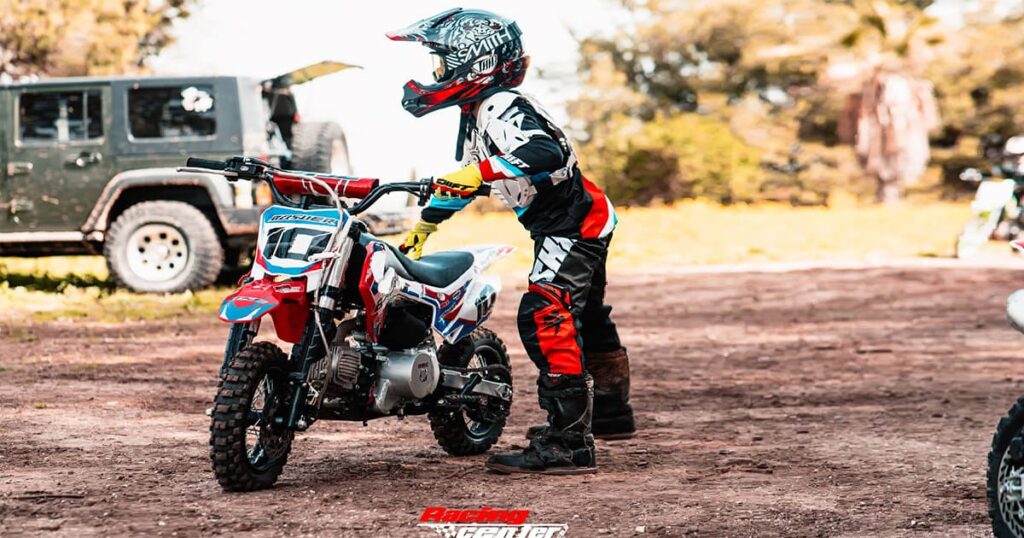 A Young dirt bike rider is preparing riding an off-road motorcycle